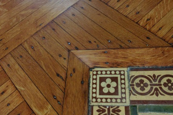 Restored wood floor detail with tile border