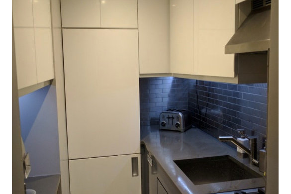 Compact kitchen remodel with white cabinets and dark tile backsplash
